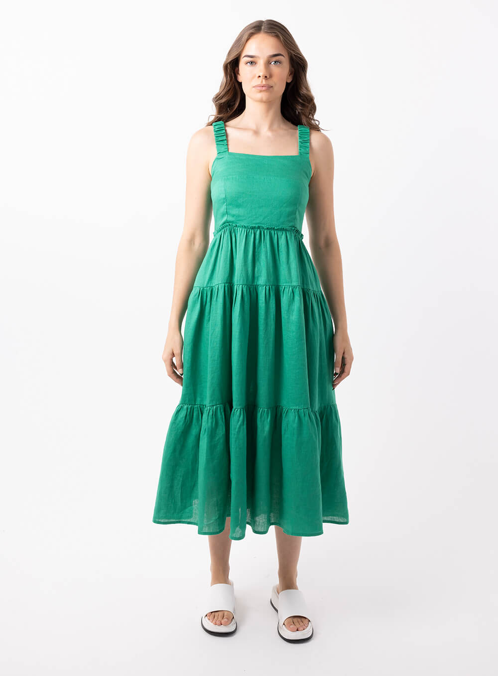 The Finlay Linen dress in green is made from 100% breathable linen, featuring a tiered skirt, thin rouched straps and 2 side pockets