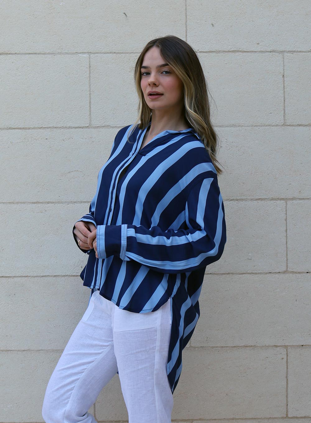 Apre stripe shirt features, super draping rayon fabric, 2 tone thick stripe pattern in navy and light blue, button through front, button down cuff, curved hem with longer tail. 