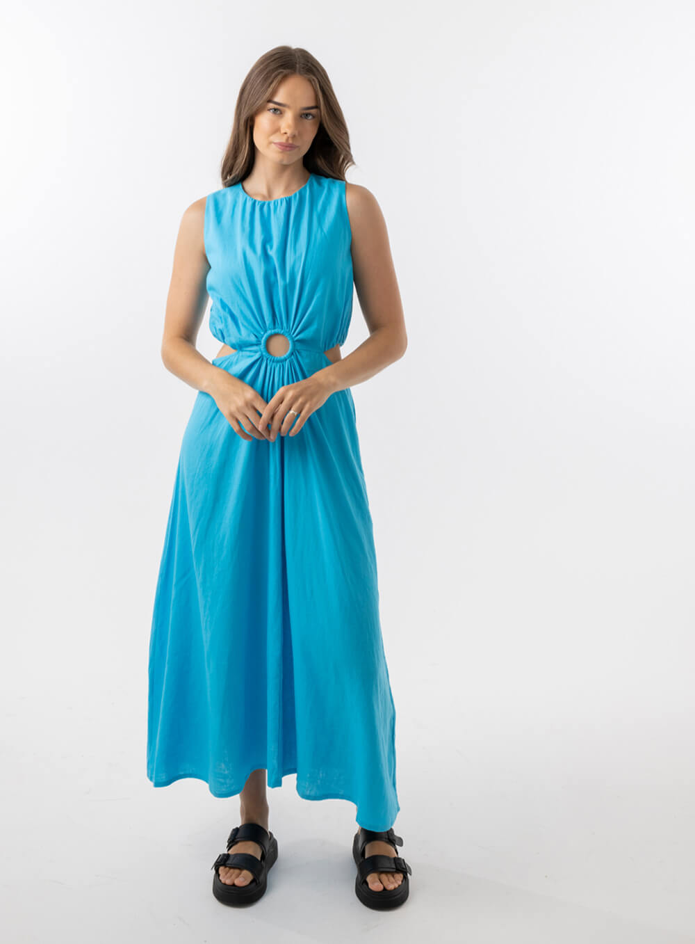 Bella Dress in Aqua features a gathered neckline, sleeveless, small cut outs at top and side of hips, with a a small ring above belly button and midi in length with a flowing skirt.