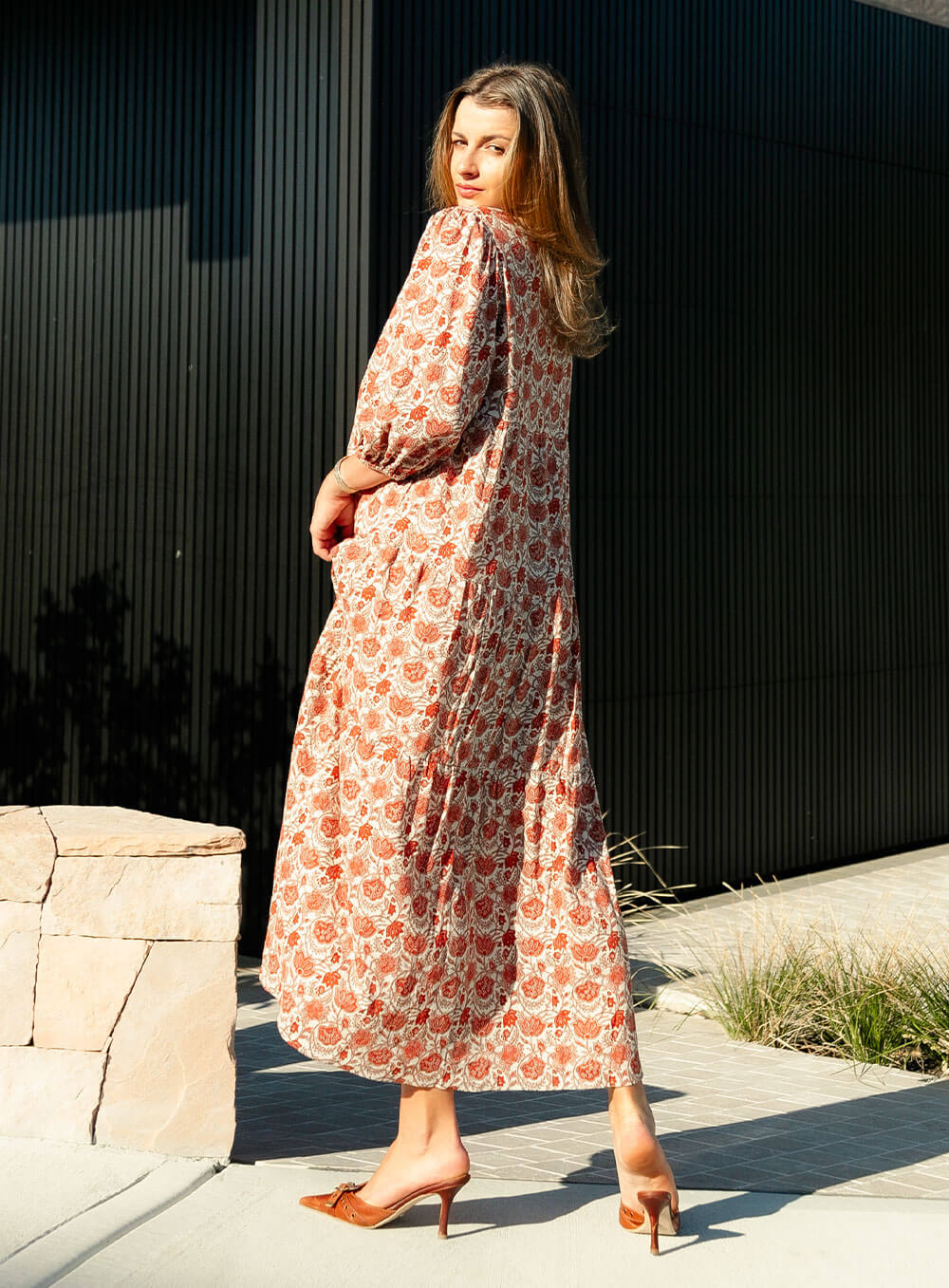 The Charlize linen dress has an all over brownie red print on a cream coloured background. It's lined, elasticated Sleeve, tiered style and front bodice detailing