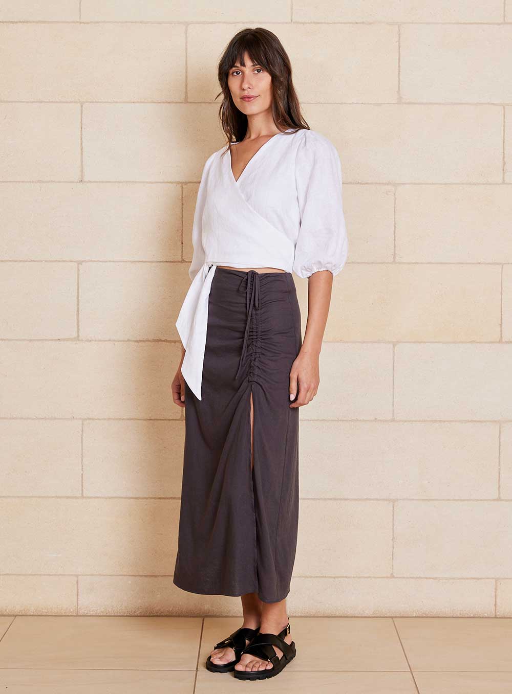 The Lily Skirt in charcoal features a ruched split detailing that adds both shape and texture, functional ruching with tie leg splits and invisible zip back seam.