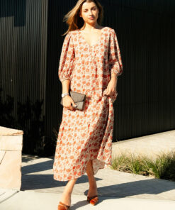 The Charlize linen dress has an all over brownie red print on a cream coloured background. It's lined, elasticated Sleeve, tiered style and front bodice detailing