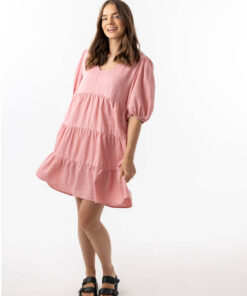 The Eleanor mini dress in blush pink features a flowing layered a line shape with draping linen/viscose fabric, puff 3/4 sleeves with elastic cuff which can be pushed up to the elbow, a dropped v shape neckline with a square finish.