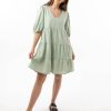 The Eleanor mini dress in sage features a flowing layered a line shape with draping linen/viscose fabric, puff 3/4 sleeves with elastic cuff which can be pushed up to the elbow, a dropped v shape neckline with a square finish.