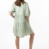The Eleanor mini dress in sage features a flowing layered a line shape with draping linen/viscose fabric, puff 3/4 sleeves with elastic cuff which can be pushed up to the elbow, a dropped v shape neckline with a square finish.