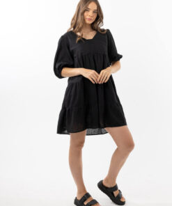 The Eleanor mini dress in black features a flowing layered a line shape with draping linen/viscose fabric, puff 3/4 sleeves with elastic cuff which can be pushed up to the elbow, a dropped v shape neckline with a square finish.