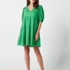 The Eleanor mini dress in green features a flowing layered a line shape with draping linen/viscose fabric, puff 3/4 sleeves with elastic cuff which can be pushed up to the elbow, a dropped v shape neckline with a square finish.