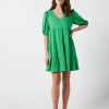 The Eleanor mini dress in green features a flowing layered a line shape with draping linen/viscose fabric, puff 3/4 sleeves with elastic cuff which can be pushed up to the elbow, a dropped v shape neckline with a square finish.