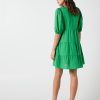 The Eleanor mini dress in green features a flowing layered a line shape with draping linen/viscose fabric, puff 3/4 sleeves with elastic cuff which can be pushed up to the elbow, a dropped v shape neckline with a square finish.