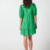 The Eleanor mini dress in green features a flowing layered a line shape with draping linen/viscose fabric, puff 3/4 sleeves with elastic cuff which can be pushed up to the elbow, a dropped v shape neckline with a square finish.