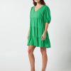 The Eleanor mini dress in green features a flowing layered a line shape with draping linen/viscose fabric, puff 3/4 sleeves with elastic cuff which can be pushed up to the elbow, a dropped v shape neckline with a square finish.