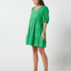 The Eleanor mini dress in green features a flowing layered a line shape with draping linen/viscose fabric, puff 3/4 sleeves with elastic cuff which can be pushed up to the elbow, a dropped v shape neckline with a square finish.